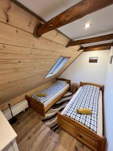 Duas camas num quarto com tectos em madeira em Pokoje gościnne 28 w skosie em Zawadka