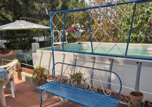 um banco azul ao lado de uma piscina em Casa vacanze Gioia em Trecastagni