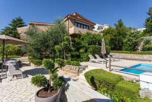 a villa with a swimming pool and a house at APARTMENTS HOUSE BARBARA 2 in Kornić