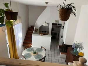 Habitación con mesa y cocina con escalera. en La maison près de la fontaine, en Talairan
