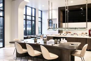 une salle à manger avec une grande table et des chaises dans l'établissement AC Hotel by Marriott Charlotte SouthPark, à Charlotte