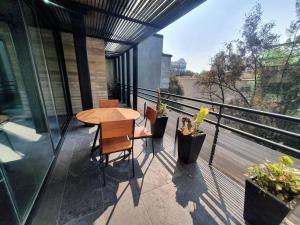 patio con mesa y sillas en el balcón en Departamento de lujo con terraza Polanco, en Ciudad de México