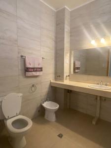 ein Badezimmer mit Toilette, Waschbecken und Spiegel in der Unterkunft Tres Marias in San Juan