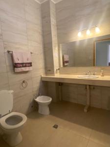 a bathroom with a toilet and a sink and a mirror at Tres Marias in San Juan