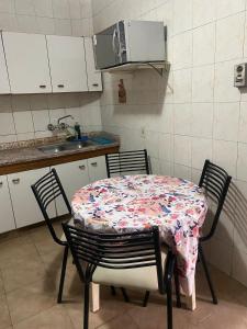 a kitchen with a table and chairs with a tablecloth on it at Tres Marias in San Juan