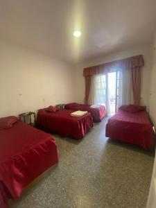 3 camas en una habitación con sábanas rojas en Tres Marias en San Juan