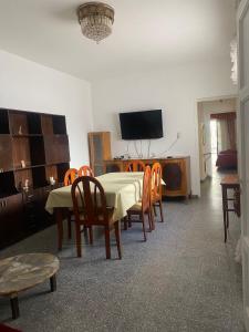 a dining room with a table and chairs and a television at Tres Marias in San Juan