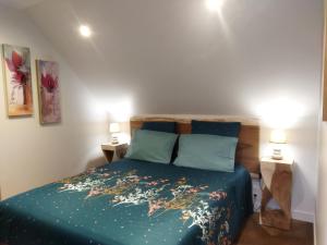 Chambre d'hôtes Seiz Breur في لونسيو: غرفة نوم بسرير من الشراشف الزرقاء ومصباحين