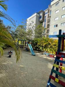 um parque infantil com um escorrega em frente a um edifício em Mountain View Cibao em Santiago de los Caballeros