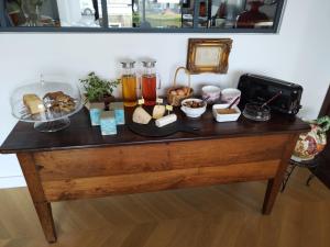 Chambre d'hôtes Seiz Breur في لونسيو: طاولة عليها طعام ومشروبات