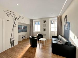 un soggiorno con un divano nero e una TV di The Place to Be in Sion a Sion