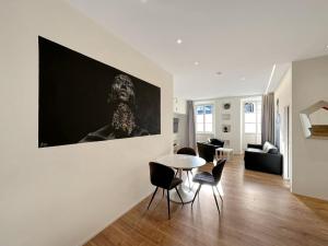 un soggiorno con tavolo e un dipinto sul muro di The Place to Be in Sion a Sion