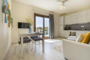 eine Küche und ein Wohnzimmer mit einem Tisch und einem Sofa in der Unterkunft 1 - Villa Is Orrosas - Apartments 1 - Sa Crai Apartments Sardinian Experience in Lotzorai