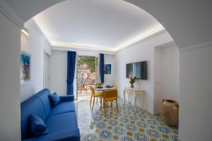 ein Wohnzimmer mit einem blauen Sofa und einem Tisch in der Unterkunft CASA DONNA LINDA in Maiori
