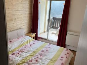 ein Schlafzimmer mit einem Bett und einem großen Fenster in der Unterkunft Appartement Bolquère-Pyrénées 2000, 3 pièces, 8 personnes - FR-1-592-57 in Font Romeu Odeillo Via
