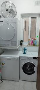 a kitchen with a washing machine and a microwave at Modern, spacious and bright apt in centre of Malta in Mosta