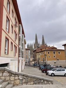 a city street with cars parked next to buildings at La Catedral Home in Burgos