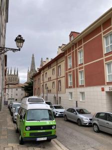 a green and white van parked on a city street at La Catedral Home in Burgos