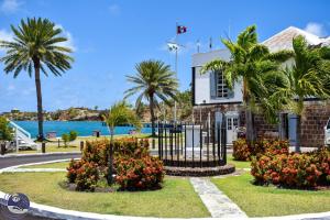 una casa con palmeras frente al agua en Copper and Lumber Store Hotel, en English Harbour Town