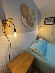 ein Schlafzimmer mit einem Bett, einem Tisch und einer Lampe in der Unterkunft Casa familiar pé na areia in Cabo Frio