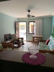 ein Wohnzimmer mit einem Sofa und einem Tisch in der Unterkunft Casa familiar pé na areia in Cabo Frio
