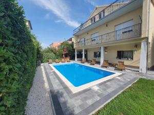 a swimming pool in front of a house at Villa Isabella with private heated pool in Kaštela