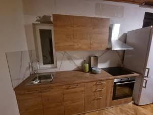 a kitchen with wooden cabinets and a sink and a refrigerator at Batea 2 in Seline