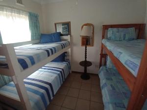 a bedroom with two bunk beds and a lamp at Neptune corner in Hibberdene