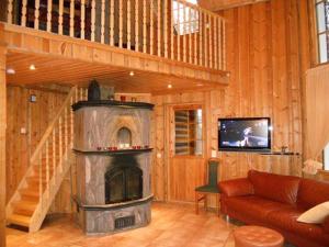- un salon avec une cheminée et un escalier dans l'établissement Mökki Ketunlenkki, à Levi