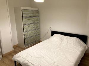 a white bed in a room with a window at Appartement Rebouc in Hèches