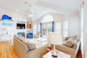 a living room with two couches and a table with a lamp at Pamlico Sunset #8-9 in Avon