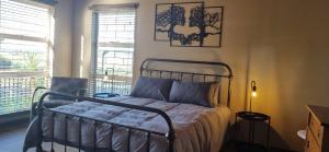 a bedroom with a metal bed in a room with windows at Rand Self-catering Accommodation in Carolina