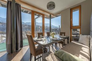 - une salle à manger avec une table et un canapé dans l'établissement Residenz am Aichwaldsee - mountainview and near lake, à Unteraichwald