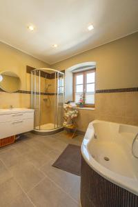 a large bathroom with a tub and a shower at Residenz am Aichwaldsee - mountainview and near lake in Unteraichwald