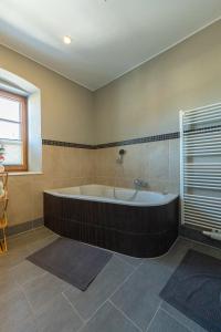 a large bathroom with a tub and a window at Residenz am Aichwaldsee - mountainview and near lake in Unteraichwald