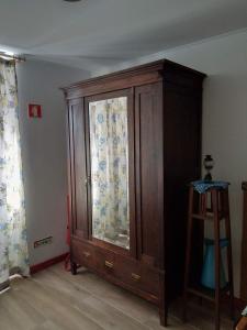 a large wooden cabinet in the corner of a room at Casa do Carregal in Braga