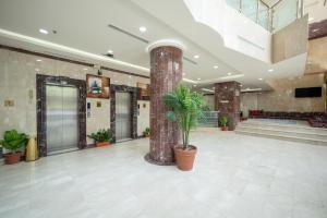 a lobby with a pillar and plants in it at فندق الفنار العزيزية in Makkah