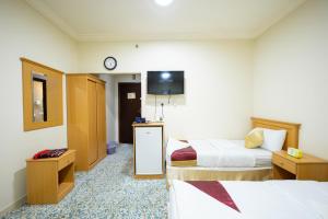 En eller flere senge i et værelse på فندق الفنار العزيزية