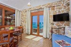 a living room with a stone wall at Plaka Beach Cottages in Pláka