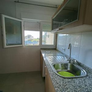 - une cuisine avec un évier et 2 fenêtres dans l'établissement Chalet Lanzada, à Sanxenxo