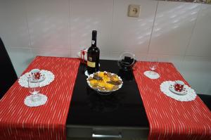 zwei rote Tische mit einer Flasche Wein und einer Schale Obst in der Unterkunft Domus Porto Perfeito in Porto