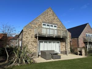 a large brick house with a balcony and a table at Ocean Retreat in Filey