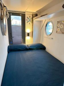 Bett in einem kleinen Zimmer mit Fenster in der Unterkunft Houseboat Seabreeze in Alghero