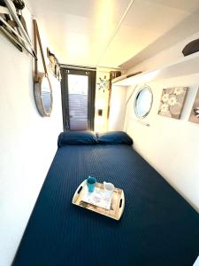 a bed in a small room with a tray on it at Houseboat Seabreeze in Alghero