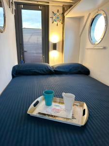 uma bandeja com duas xícaras numa cama num avião em Houseboat Seabreeze em Alghero