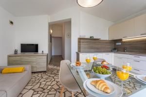 a living room with a table with food and glasses of wine at APARTMENTS HOUSE BARBARA 2 in Kornić