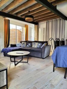 een woonkamer met een bank en een tafel bij Gite du four à pain in Benais