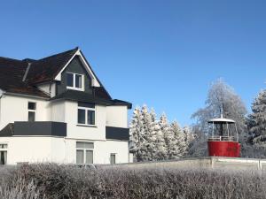 a house with a lighthouse in front of it at Berghotel HARZ in Hahnenklee-Bockswiese