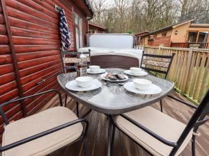 a table and chairs on a deck with a truck at Brightwater Lodge in Windermere