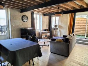Gite du four à pain في Benais: غرفة معيشة مع طاولة وأريكة